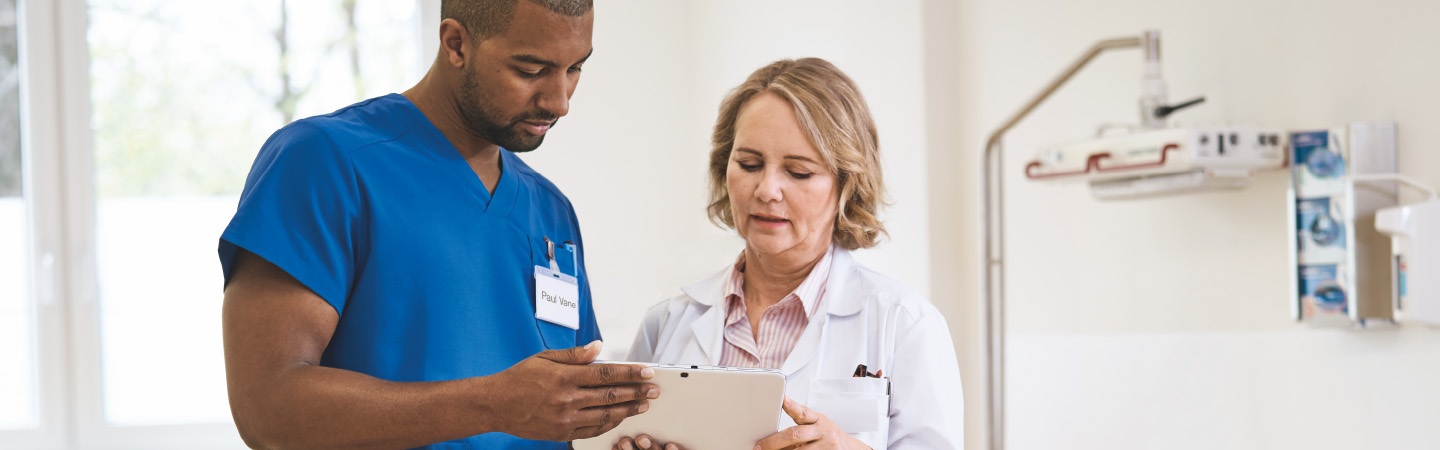 A nurse and a doctor looking at a tablet.  A nurse and a doctor looking at a tablet.